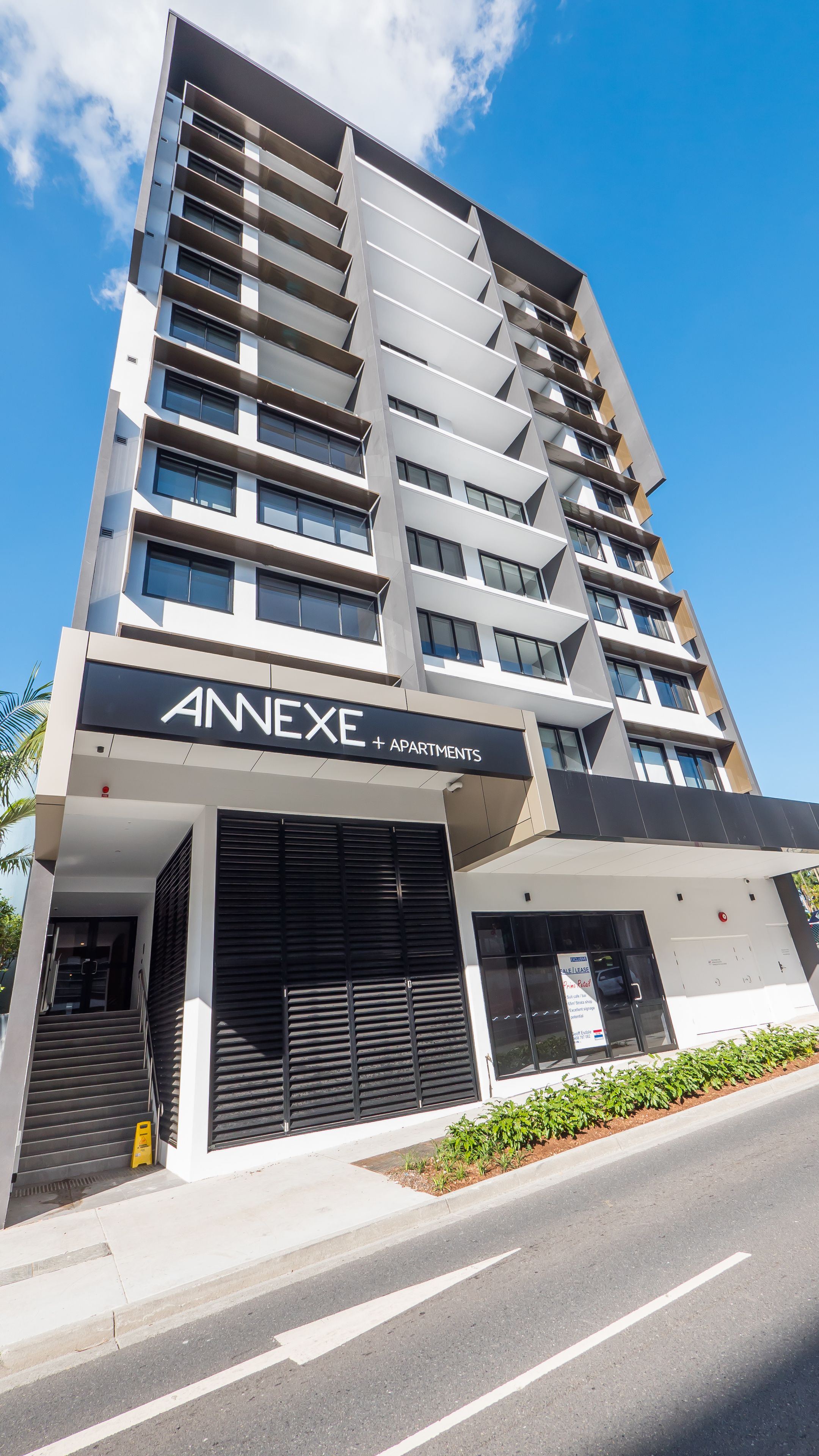 A modern multi-story building with a sign reading "ANNEXE + APARTMENTS".