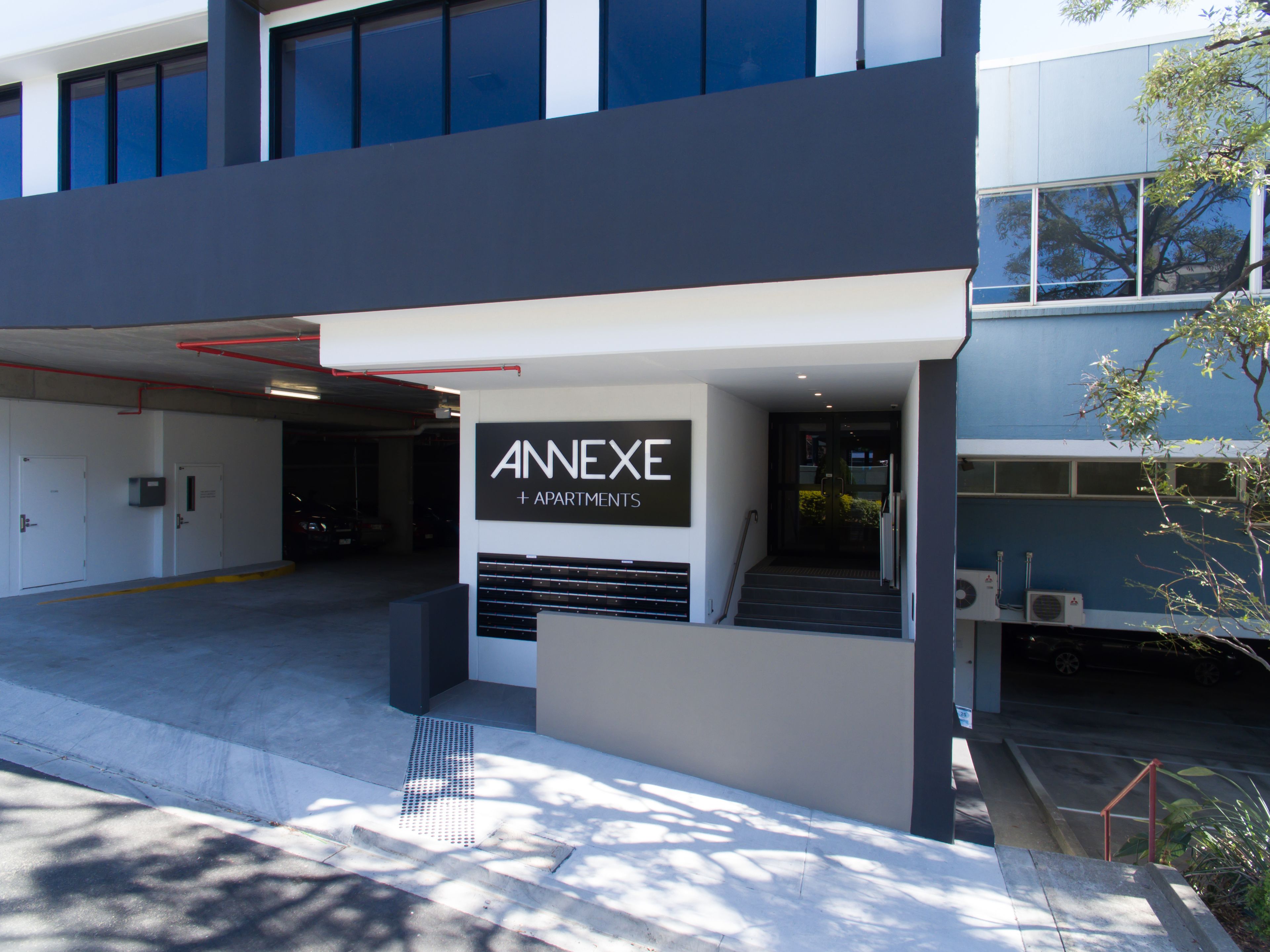 Un edificio moderno con un letrero que dice 'ANNEXE + APARTMENTS'.