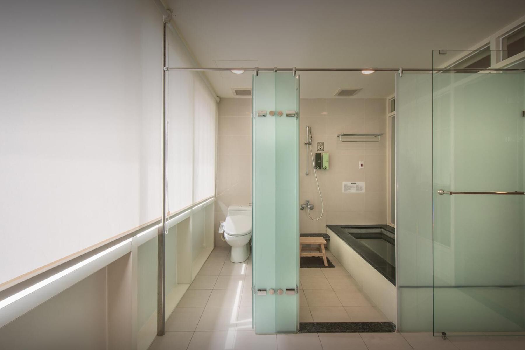 Une salle de bain moderne avec une douche à parois de verre, des toilettes et une baignoire.
