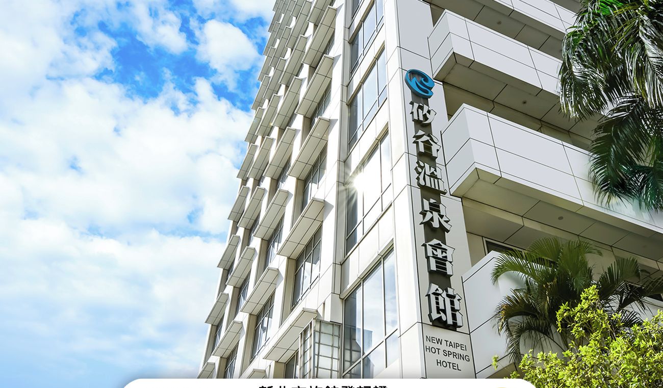 A modern hotel building with a sign indicating it is the New Taipei City Hotel Registration.