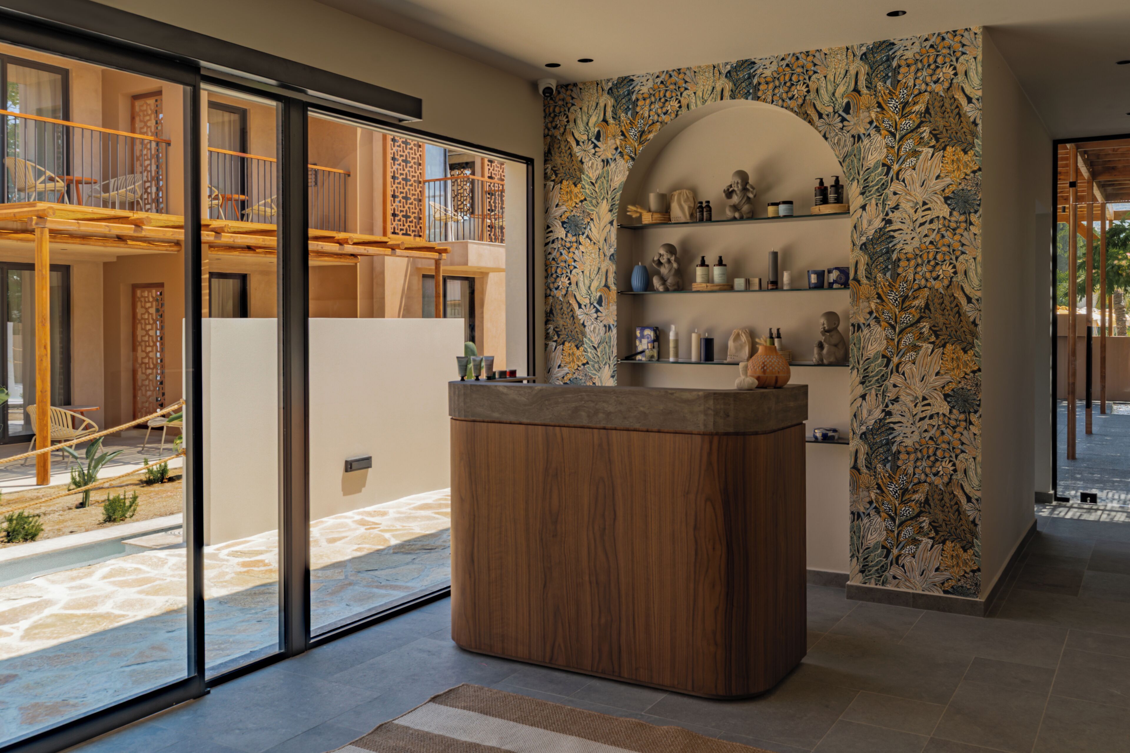 Ein modernes Interieur mit einem Holzerrepschein, einer Wand mit Muster und Blick auf einen Balkon mit Gartenmöbeln.
