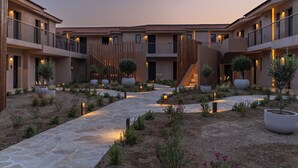 A courtyard with a stone pathway, potted plants, and a wooden fence. - Eleonas Boutique Hotel & Spa (Rhodes)