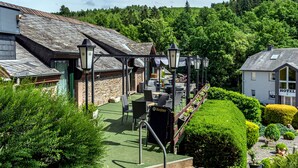 A hotel with a rooftop terrace, outdoor seating, and a well-maintained garden. - Hotel Ulftaler Schenke (Burg-Reuland)