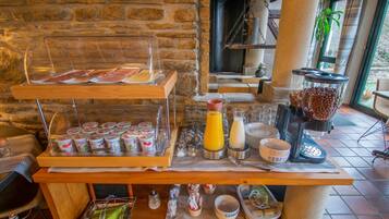 A breakfast buffet with yogurt cups, cereal, and juice.