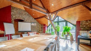A conference room with a large wooden table, whiteboard, and wicker chairs. - Hotel Ulftaler Schenke (Burg-Reuland)