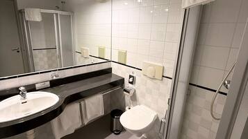 A modern bathroom with a sink, mirror, and shower.