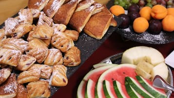 Una variedad de pasteles y frutas sobre una mesa.