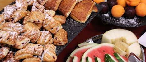 Una variedad de pasteles y frutas sobre una mesa.