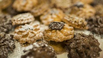 A close-up of various pastries, including some dusted with powdered sugar.