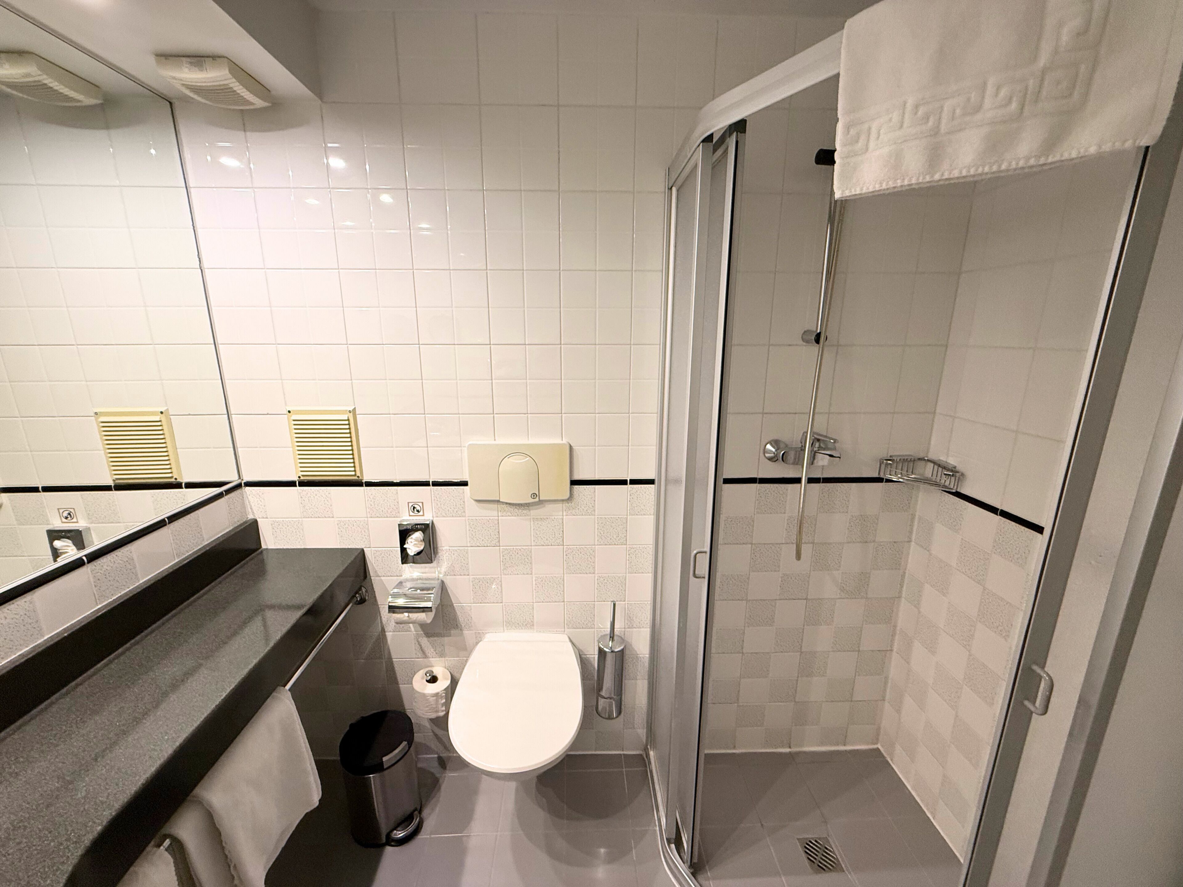 A modern bathroom with a toilet, bidet, and shower.