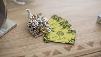 A wooden table with a decorative silver object and a yellow card labeled "Villa Anna Guest House".
