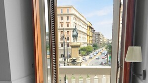 A hotel room with a balcony overlooking a street and buildings. - Piazza Bovio 22 (Naples)