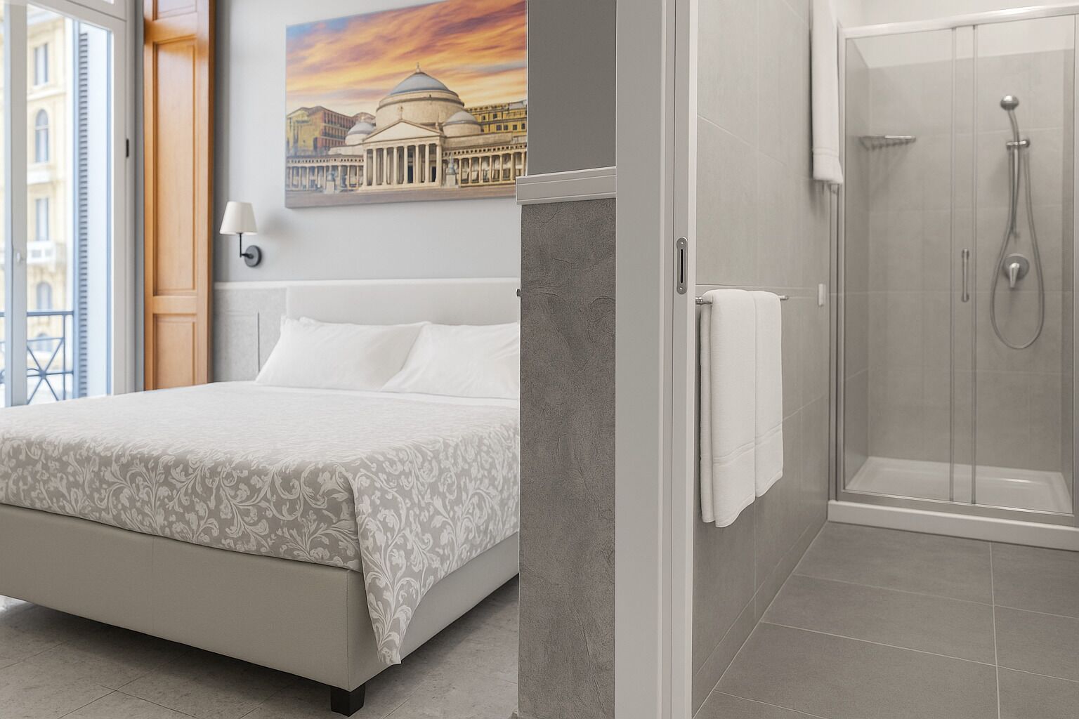 Ein Hotelzimmer mit Bett, Dusche und einem Gemälde eines Gebäudes.