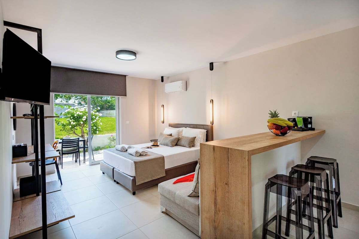 A modern hotel room with a bed, a desk, and a seating area.