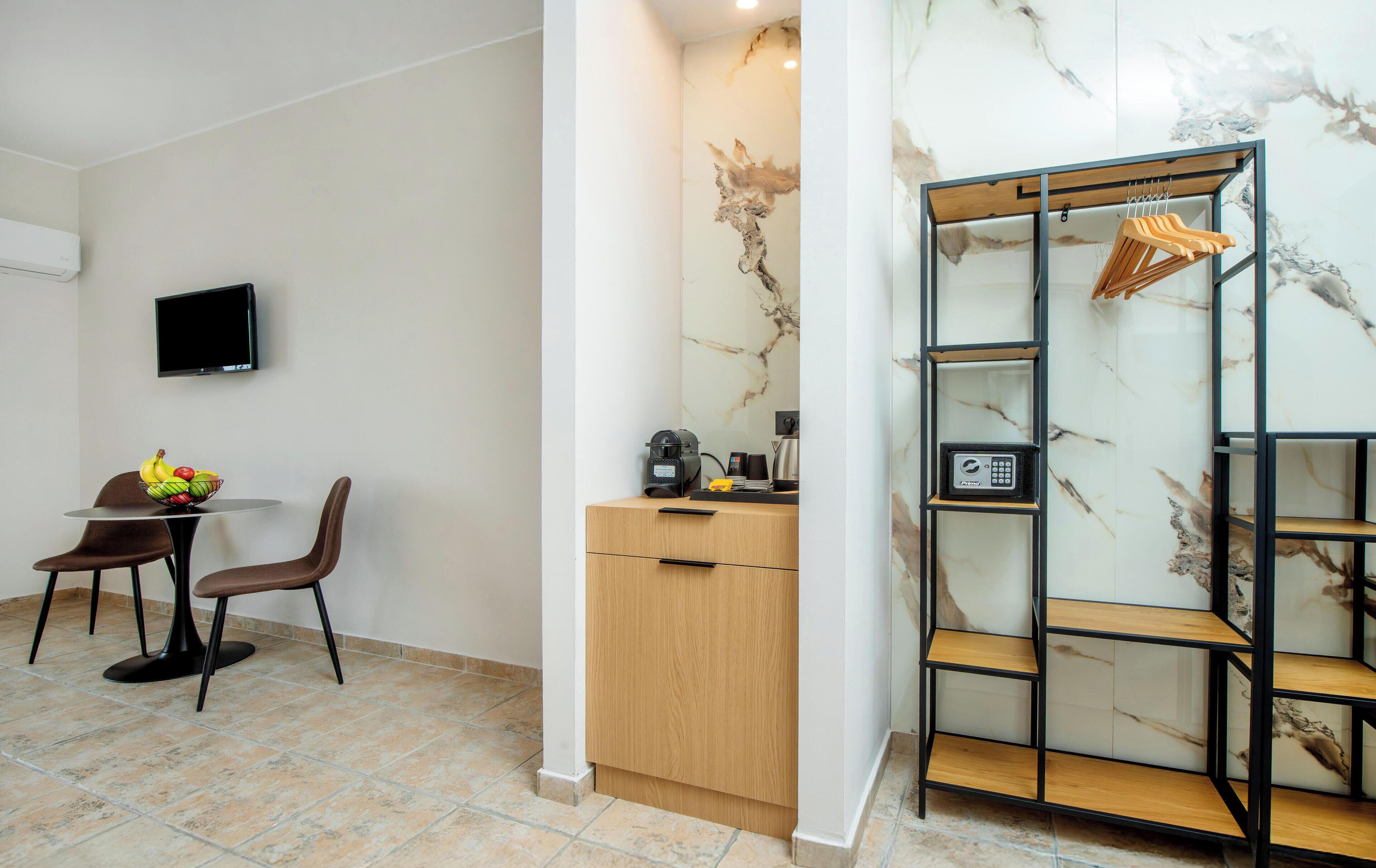 A modern room with a dining area, a wooden cabinet, a marble wall, and a metal shelf unit.