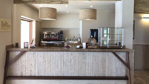 Eine Küche mit Holzvertäfelung, einer Kaffeemaschine und einer Glastheke.