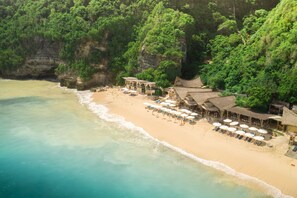 A beach resort with thatched-roof buildings, a sandy beach, and a cliffside. - The Ungasan Clifftop Resort (Pecatu)