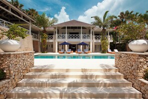 A resort with a swimming pool, stone steps, and lounge chairs. - The Ungasan Clifftop Resort (Pecatu)