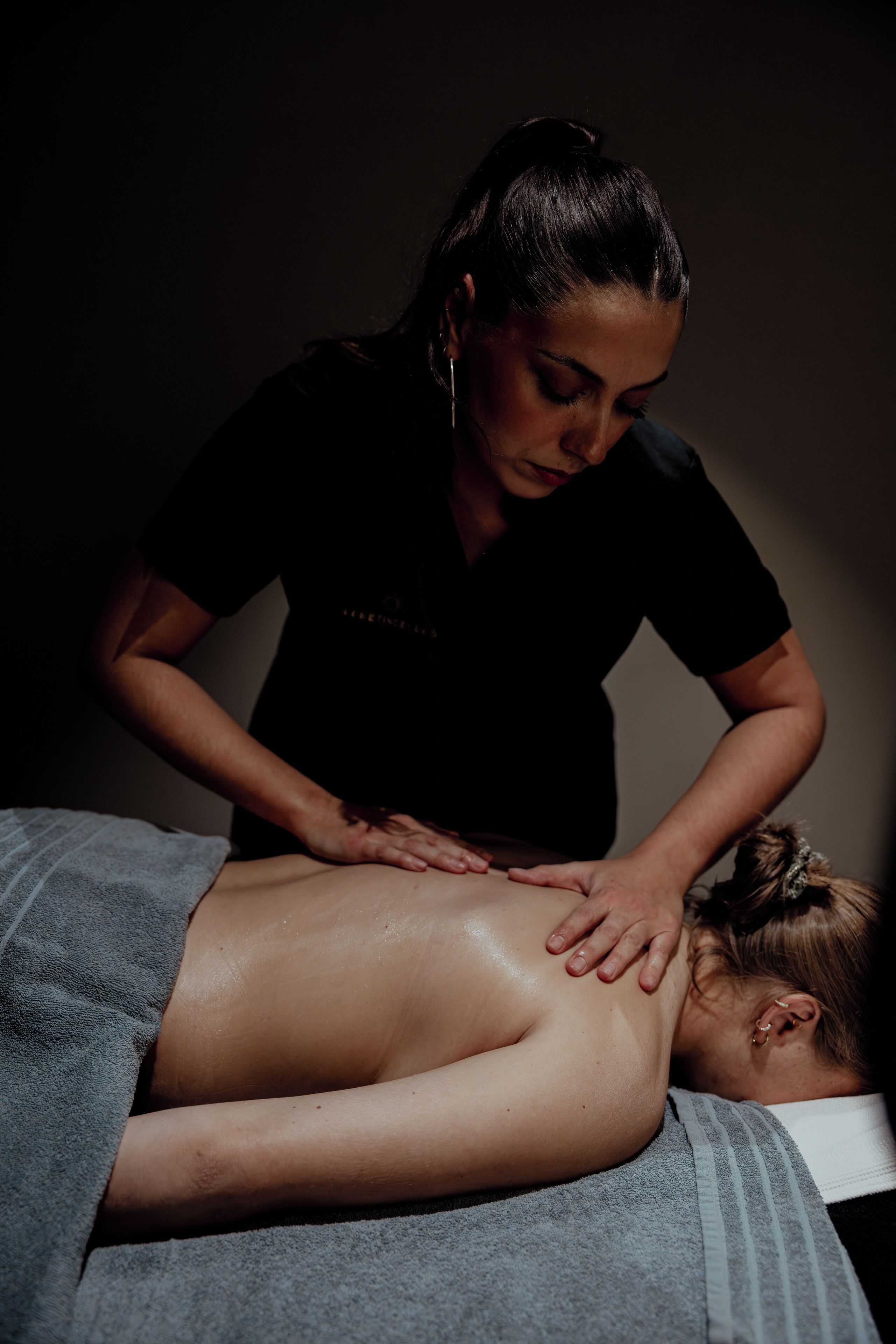 A person receiving a massage in a dimly lit room.