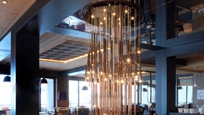A buffet with various food items and a modern chandelier. - Hôtel Taj-I Mah by Les Etincelles  (Bourg-Saint-Maurice)
