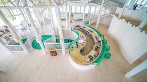 A multi-level interior with a central spiral staircase, seating areas, and a bar.