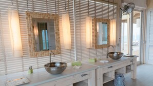 A modern bathroom with a wooden vanity, two sinks, and a large mirror.
