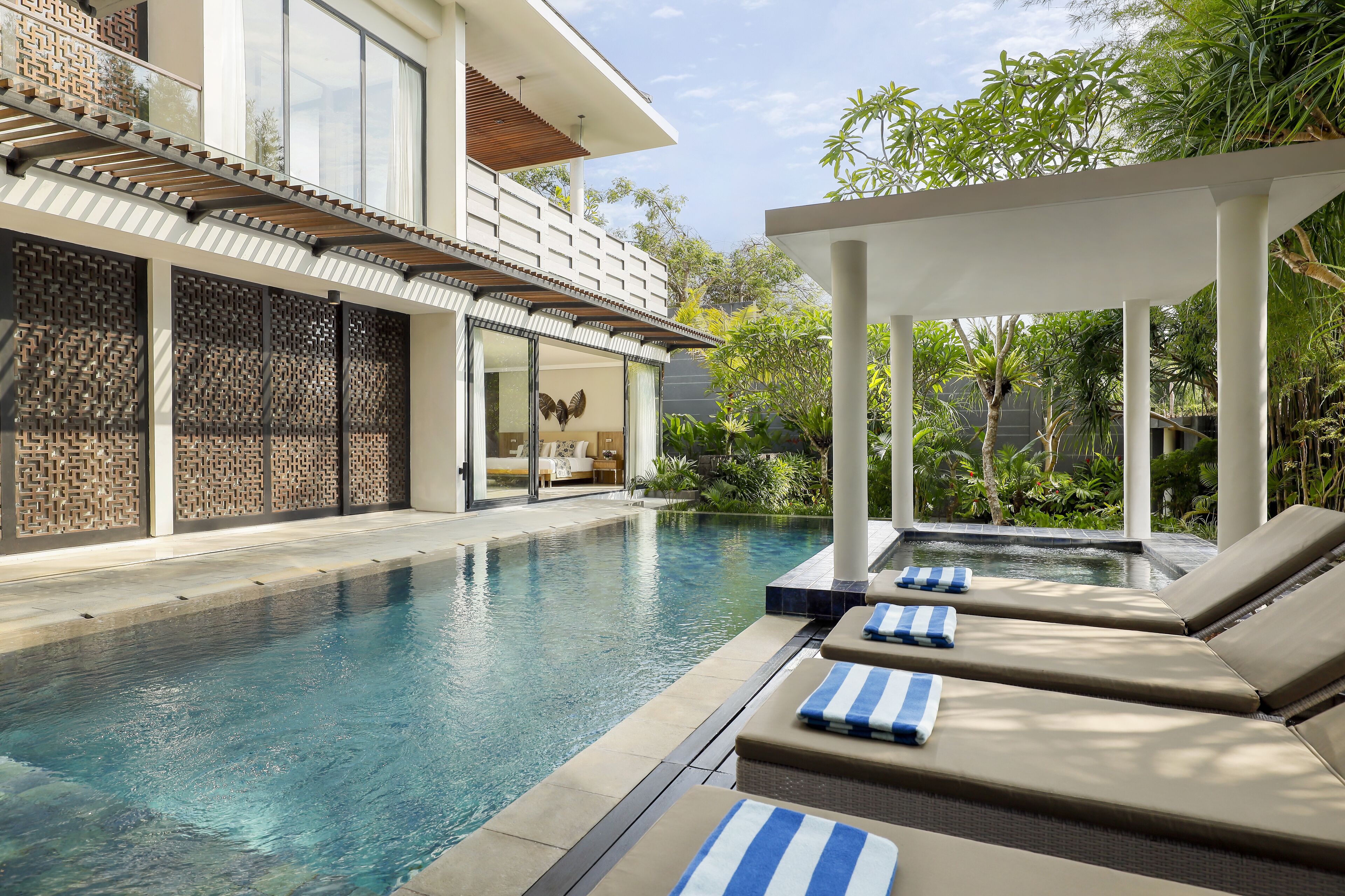 A modern pool area with lounge chairs and a pergola.