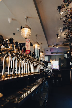 A bar with multiple taps and a beer tap labeled 'Budweiser.' - Prince of Wales - Townhouse (London)