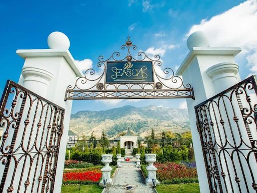A grand entrance with a sign reading "SEASON" and a mountainous backdrop.