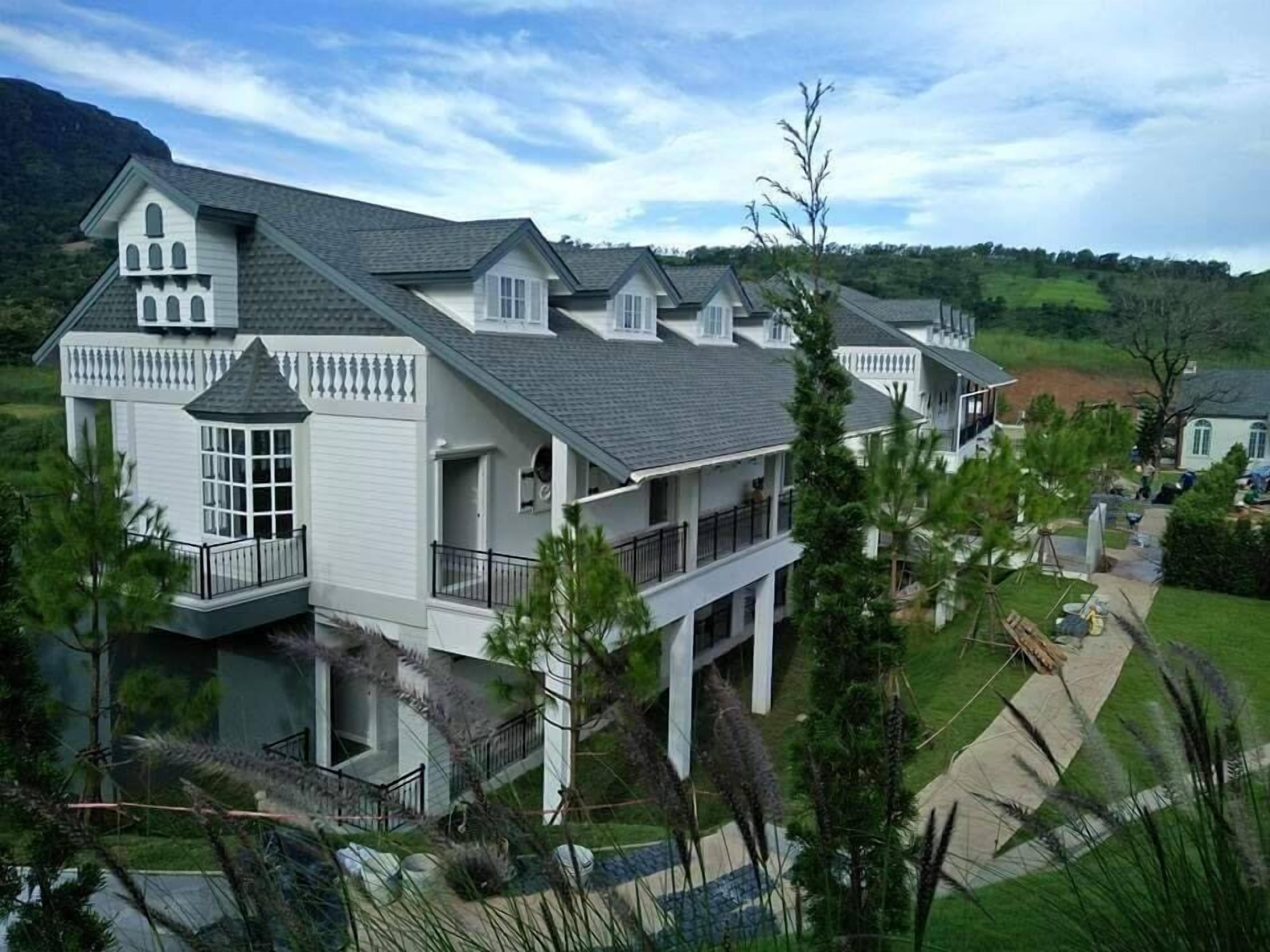 A large, multi-story house with a prominent balcony and a garage.