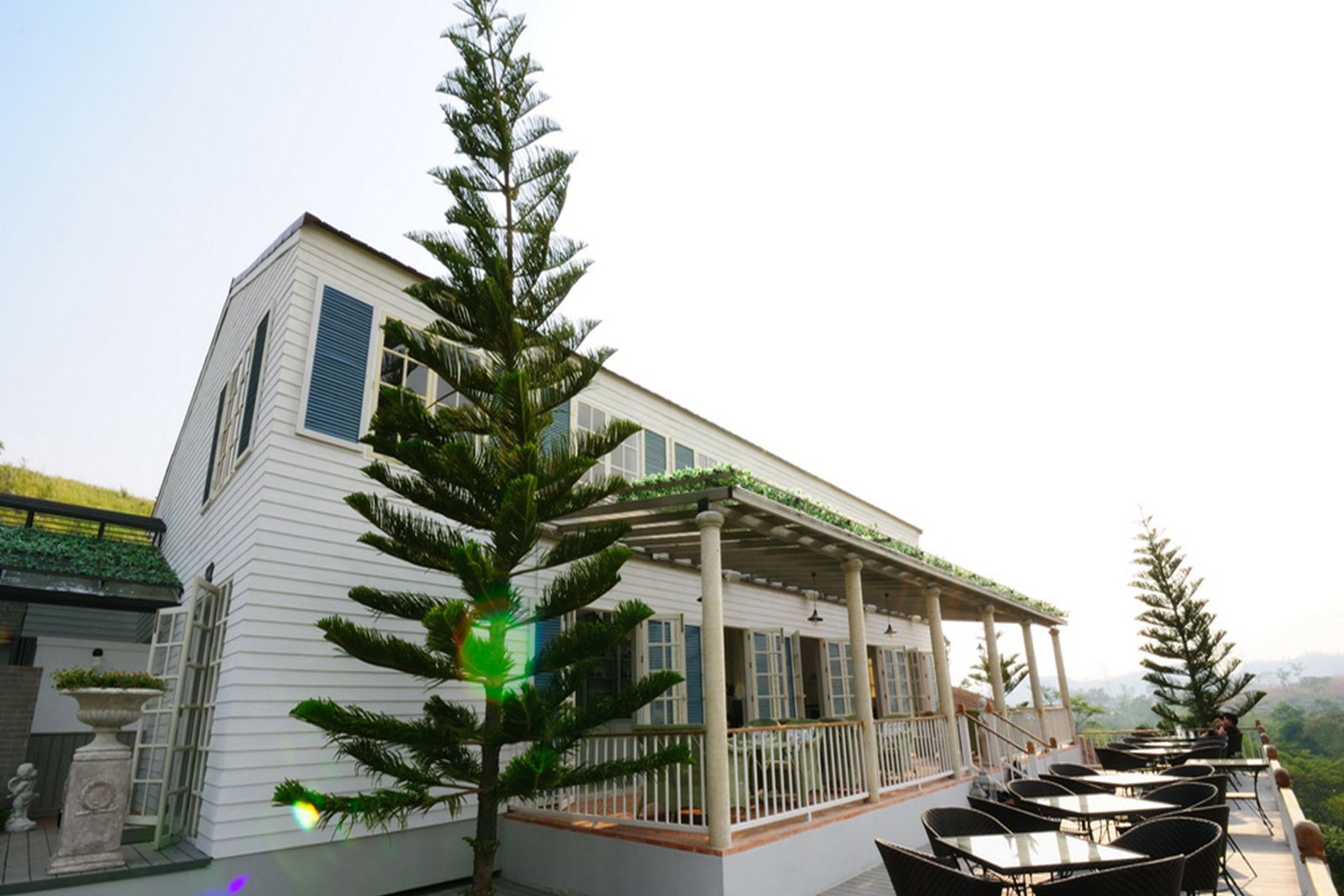 A white building with a covered patio area and outdoor seating.