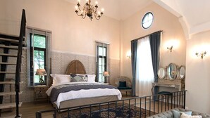 Een slaapkamer met een bed, een kroonluchter, een klok en een bank.