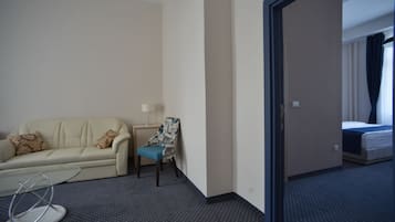 Suite junior, 1 habitación | Área de sala de estar | Televisión de pantalla plana de 39 pulgadas con canales por cable