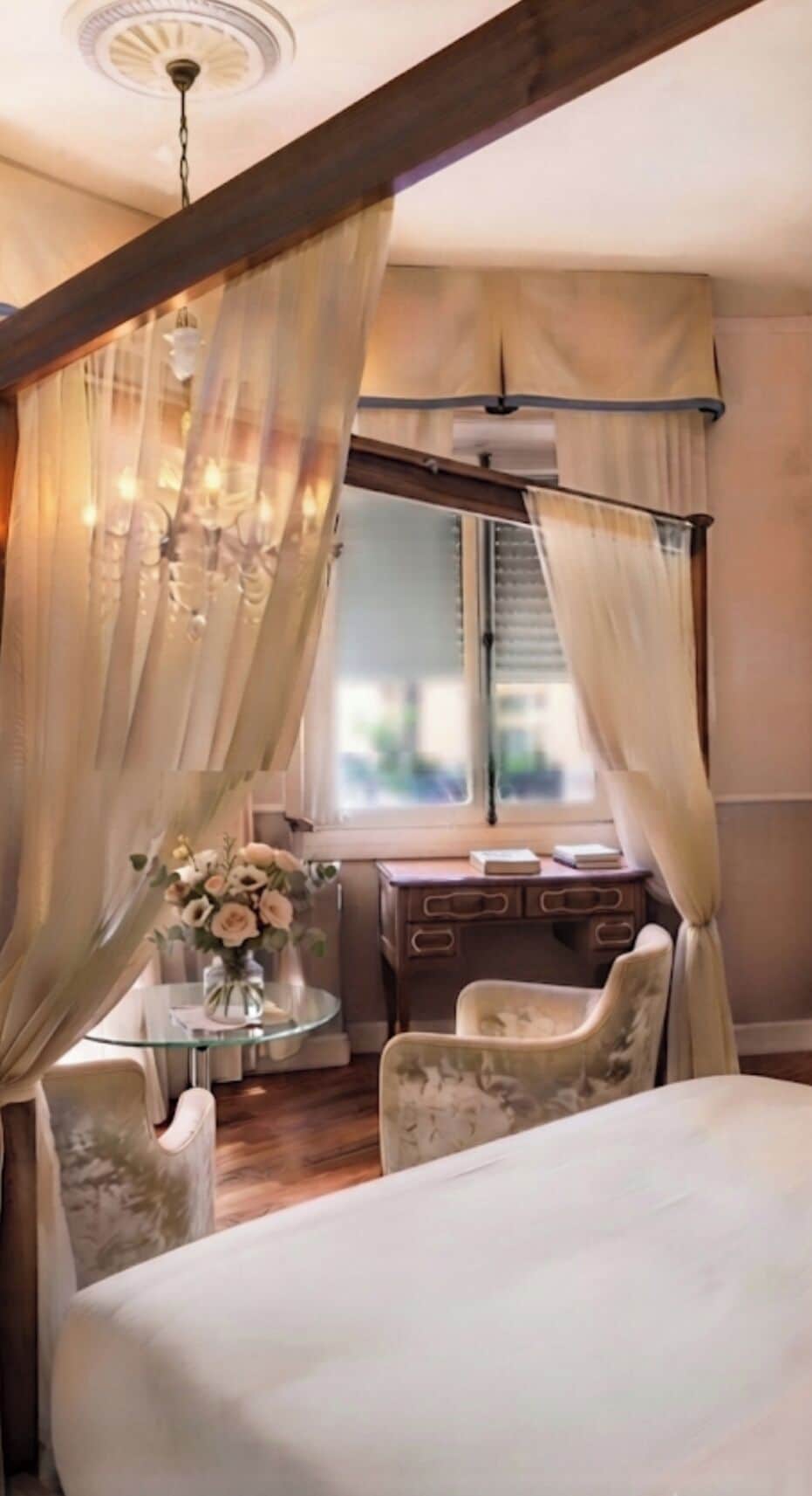 Une chambre à coucher avec un lit à baldaquin, un bureau avec une chaise et une fenêtre avec des rideaux.
