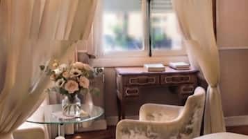 Une chambre à coucher avec un lit à baldaquin, un bureau avec une chaise et une fenêtre avec des rideaux.
