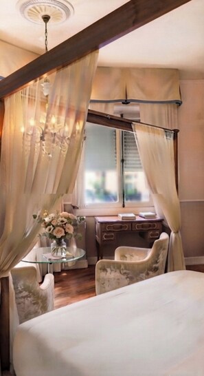 Un dormitorio con cama con dosel, un escritorio con silla y una ventana con cortinas.