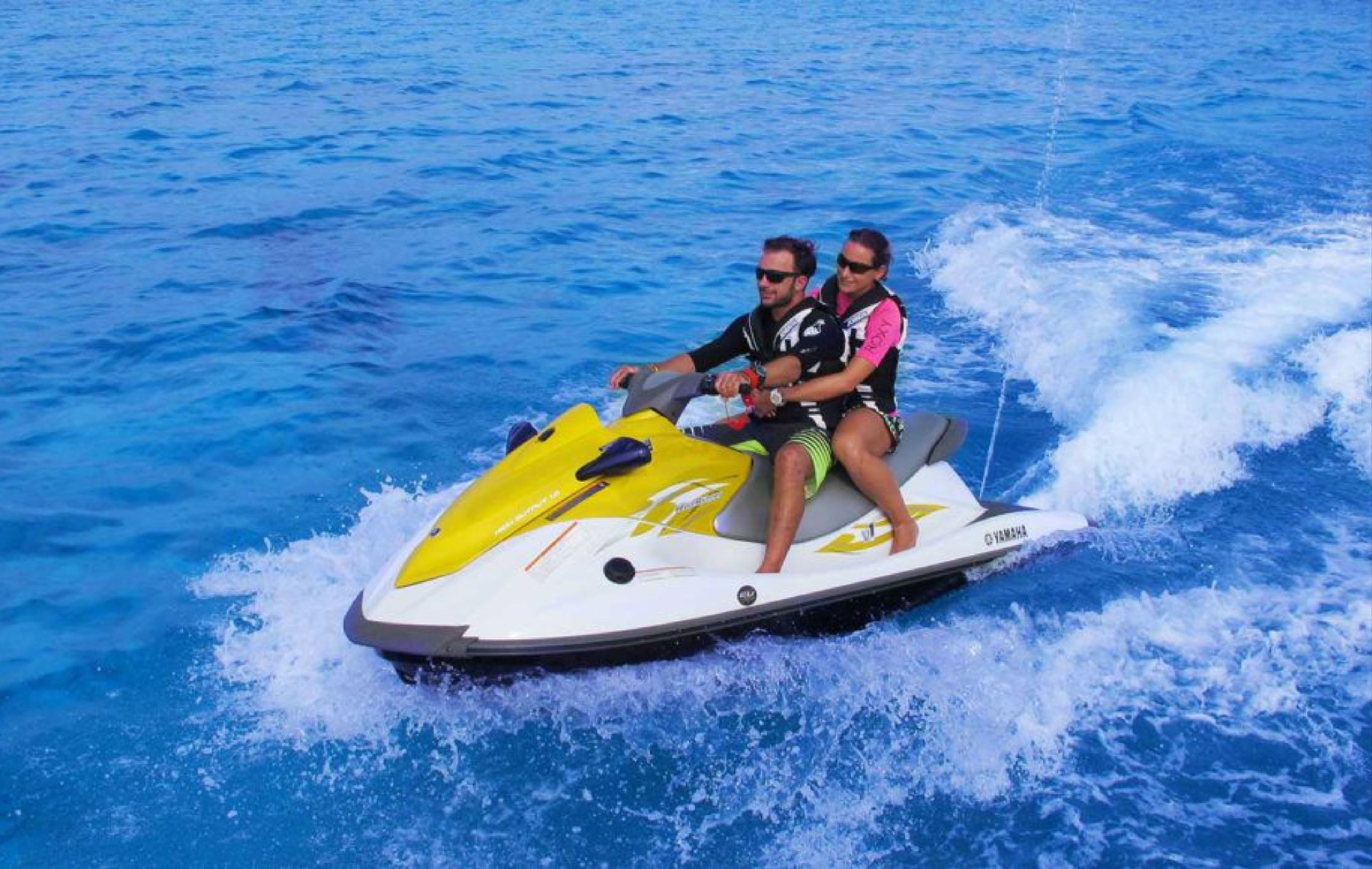 Two people on a jet ski with a Yamaha logo.
