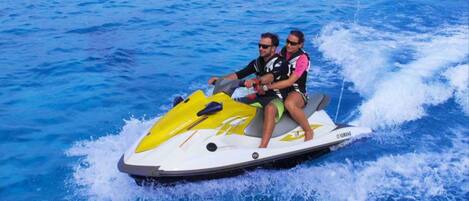 Two people on a jet ski with a Yamaha logo.