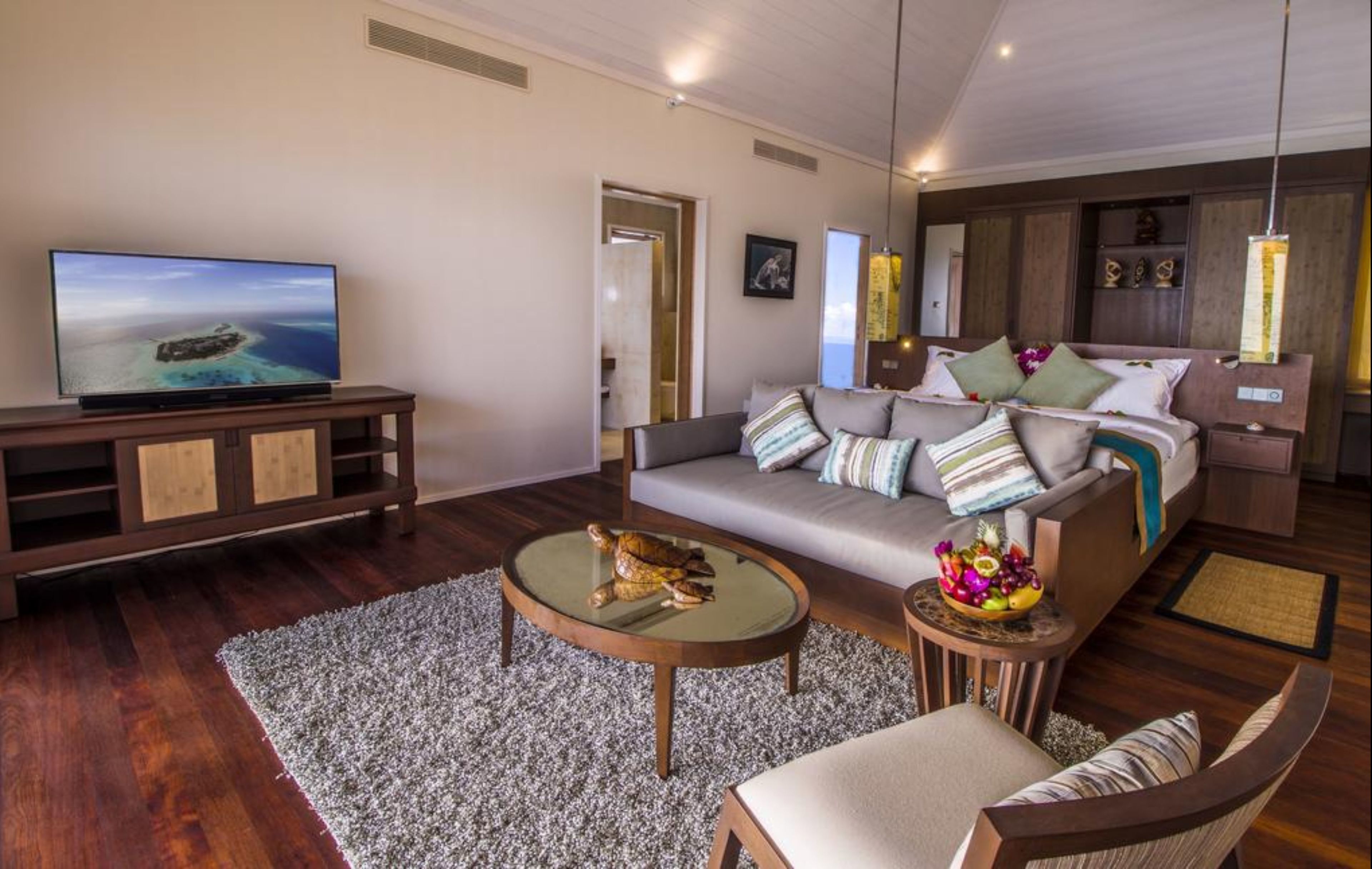 Una sala de estar moderna con sofá, mesa de centro y televisor.