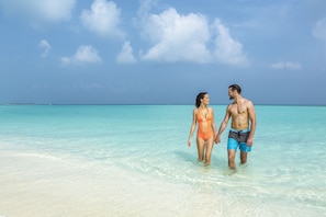 On the beach, white sand, sun loungers, beach towels