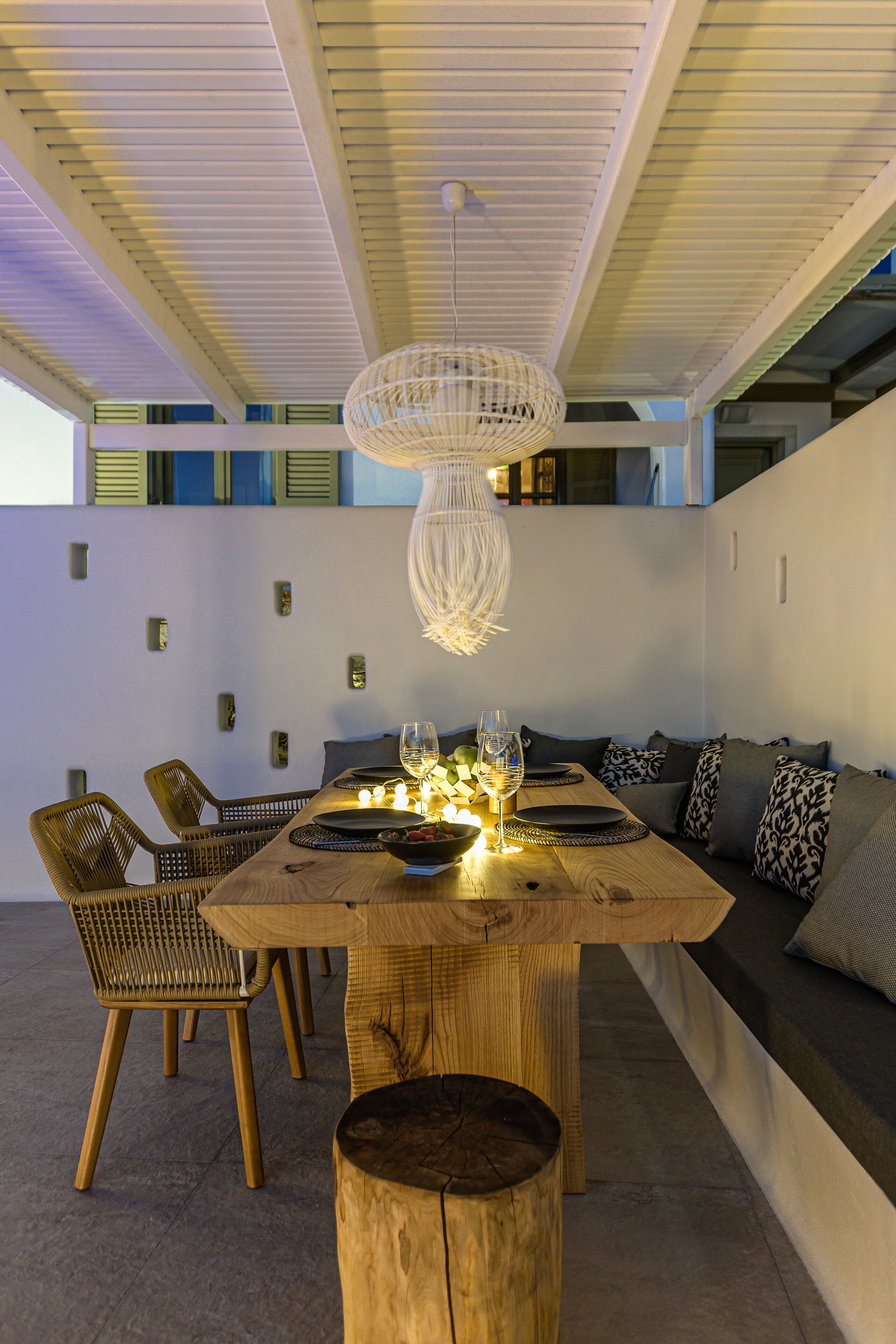 A dining area with a wooden table, chairs, and a hanging light fixture.