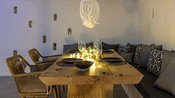 A dining area with a wooden table, chairs, and a hanging light fixture.