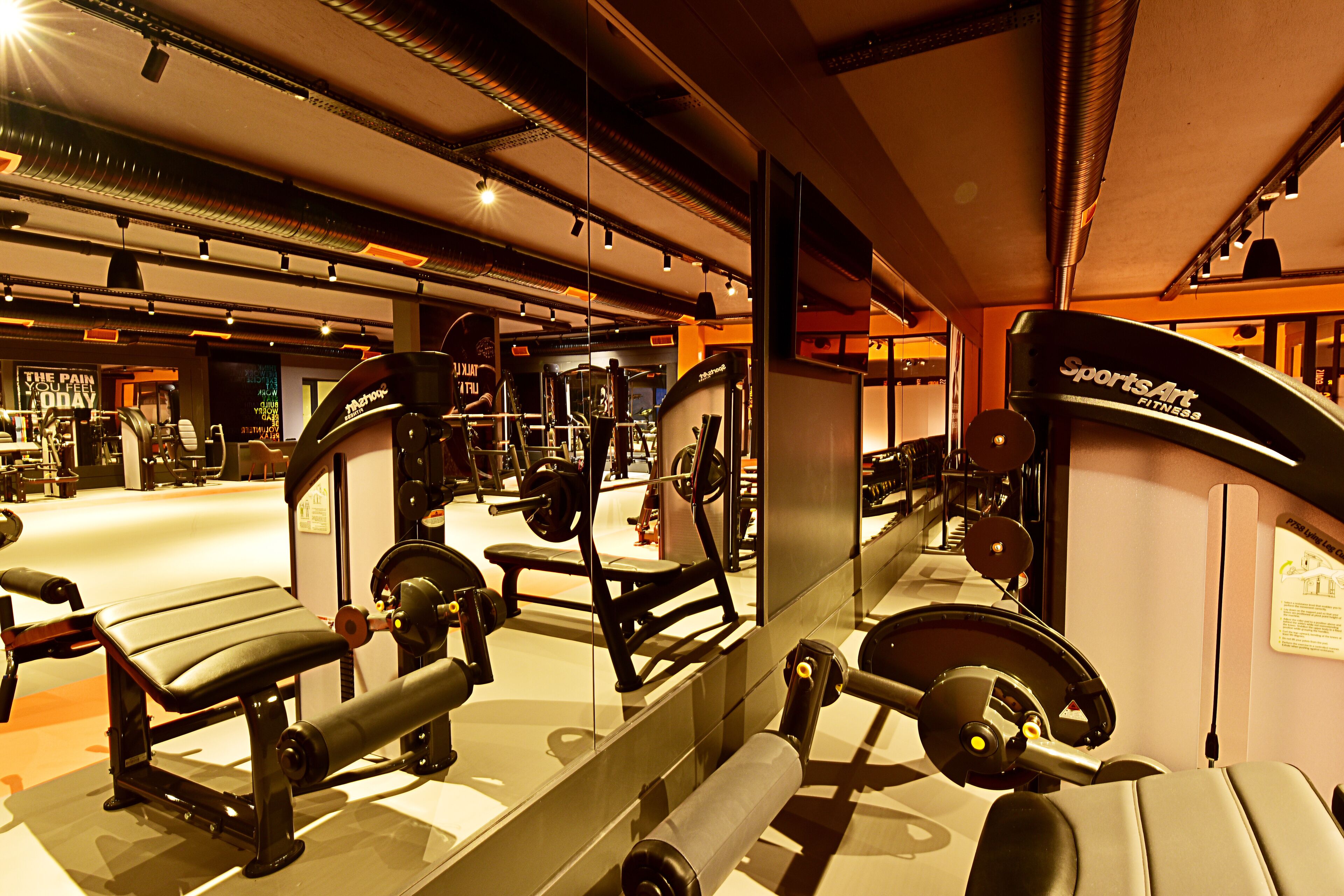 Un gimnasio con diverso equipo de ejercicio, incluyendo bancos y máquinas de pesas.
