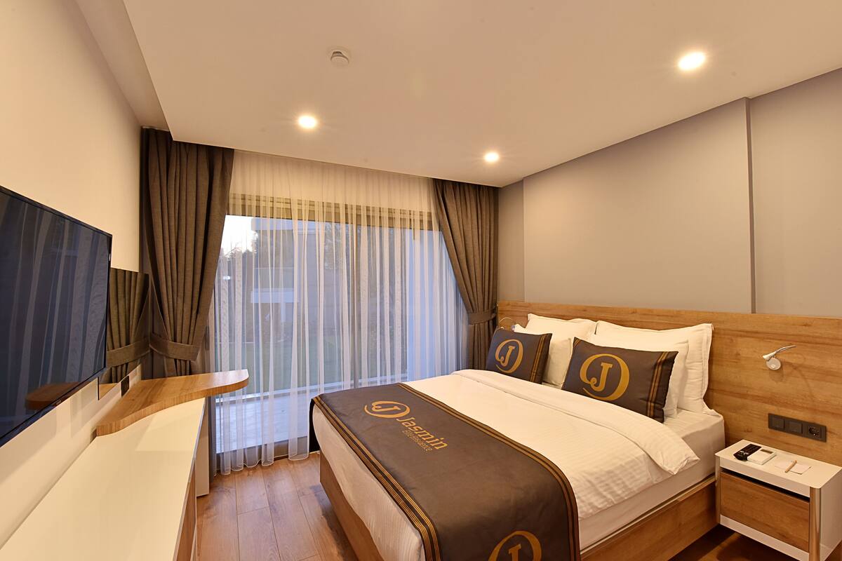 Ein Hotelzimmer mit Bett, Nachttisch und Fernseher.