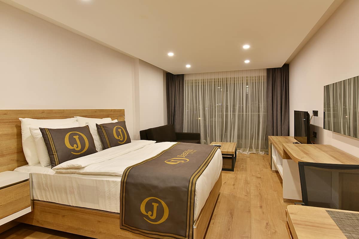 Ein Hotelzimmer mit einem großen Bett, einem Schreibtisch und einem Sessel.