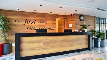 A reception desk with a wooden panel design and a black marble top.