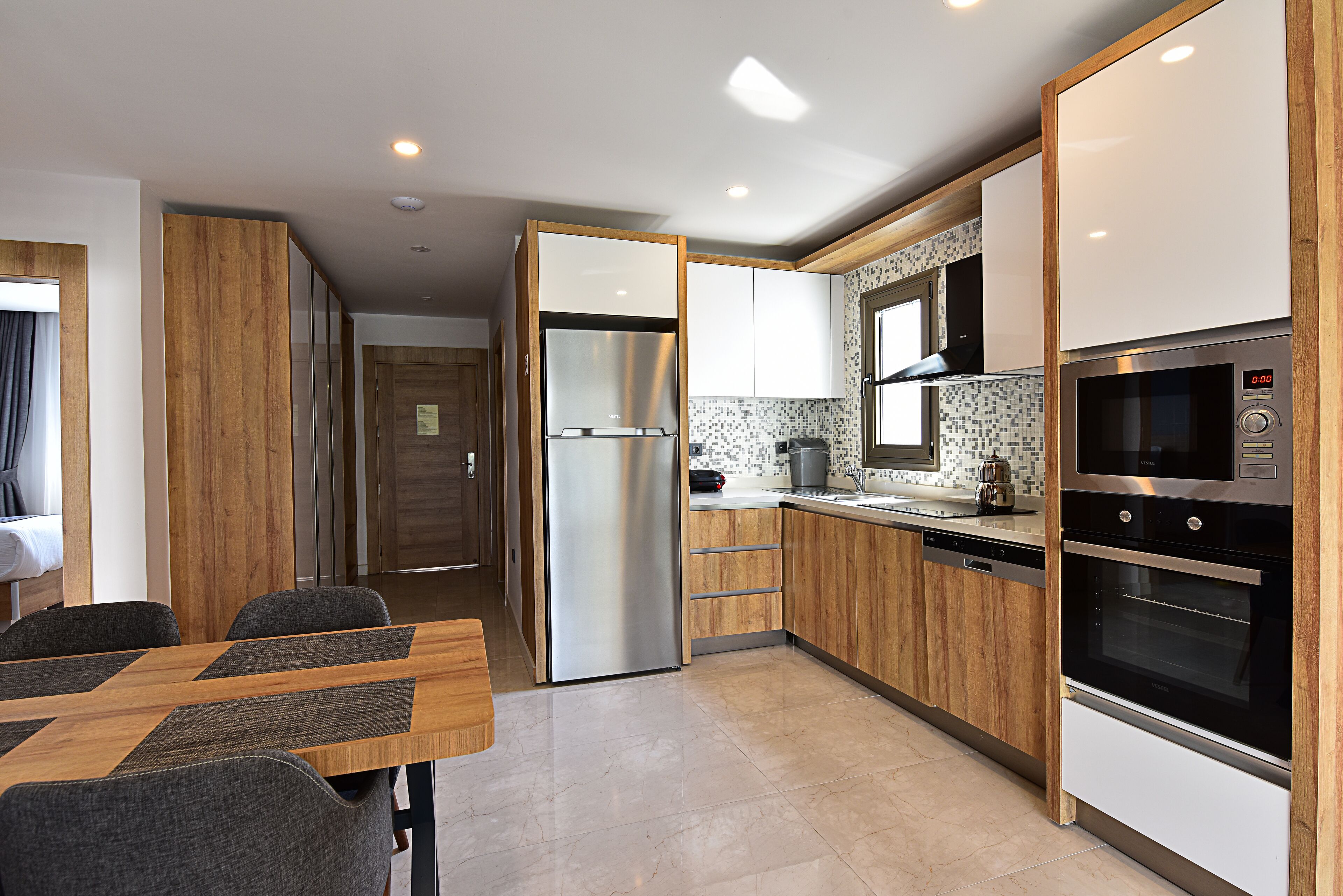 A modern kitchen with wooden cabinets, stainless steel appliances, and a tiled backsplash.