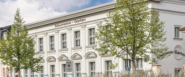 A building with the sign 'Schumann's Garten' indicating a garden or park area.