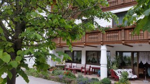 A traditional building with a balcony, outdoor seating, and potted plants. - Landhaus Aggenstein (Graen)