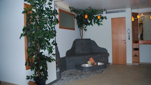 Ein Badezimmer mit einem Steinkalaps, einer Topfpflanze und einem Spiegel an der Wand.